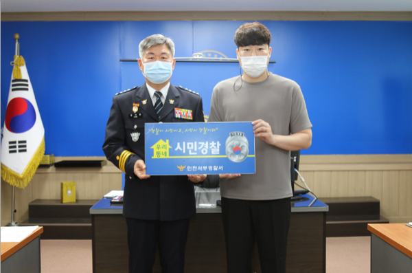 ▲  사진= 김병구 경찰청장과 심폐소생술로 의식을 잃은 운전자의 생명을 구한 유명한씨가 기념촬영을 하고 있는 모습