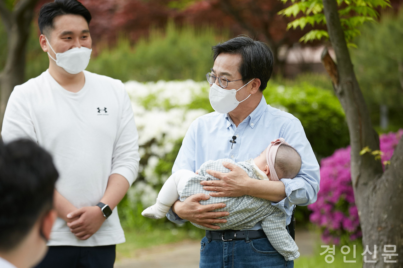 ▲ 수원 아주대에서 열린 공동후원회장 간담회장에 참석한 청년의 아이를 안고 즐거워하는 김동연 후보(4월30일)