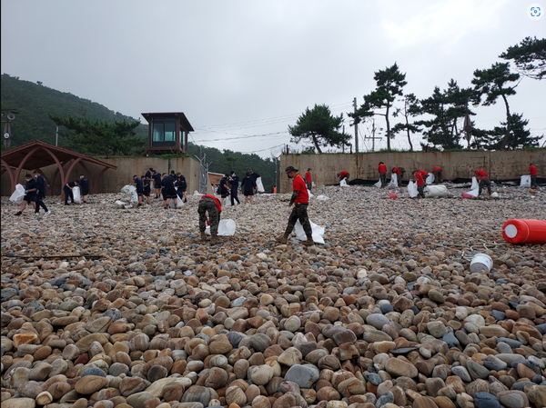   ▲사진 = 구리동 해수욕장 환경정화 활동 실시를 하고 있다.