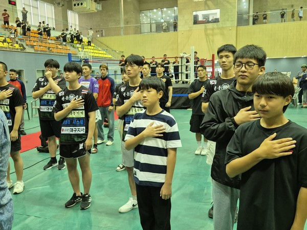 킥복싱 대회에 참석한 선수들이 국민의례을 하고있다