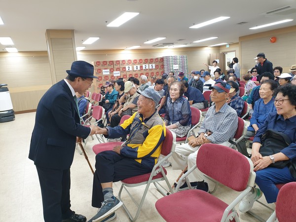 곽양섭회장이 추석나눔 행사에 참석한 회원들과 인사를 나누고있다