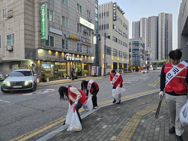 ▲고석 위원장과 청년 당원들이 거리 정화활동의 일원으로 쓰레기를 주워 담고 있다.