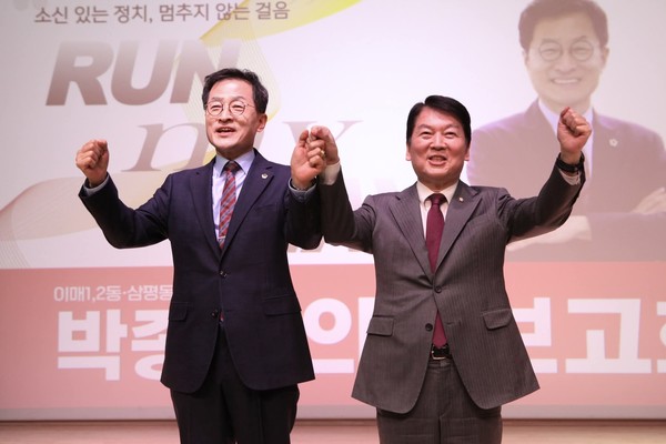 ▲안철수 국회의원(오른쪽)과 박종각 시의원이 의정보고회에 참석한 주민들을 향해 인사를 하고 있다.